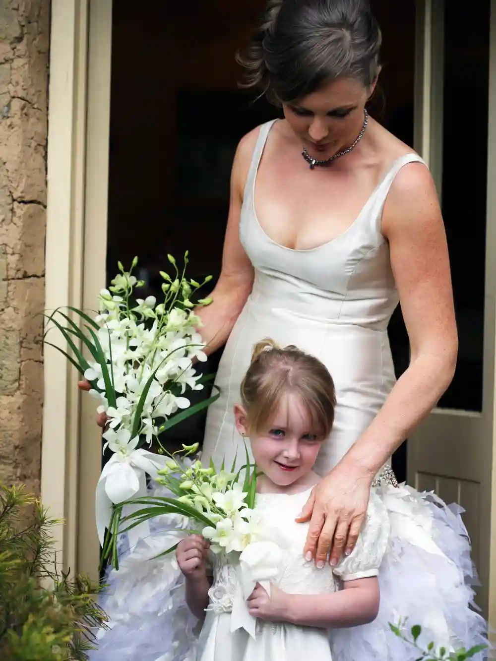 The bride and flower girl wear white dresses
