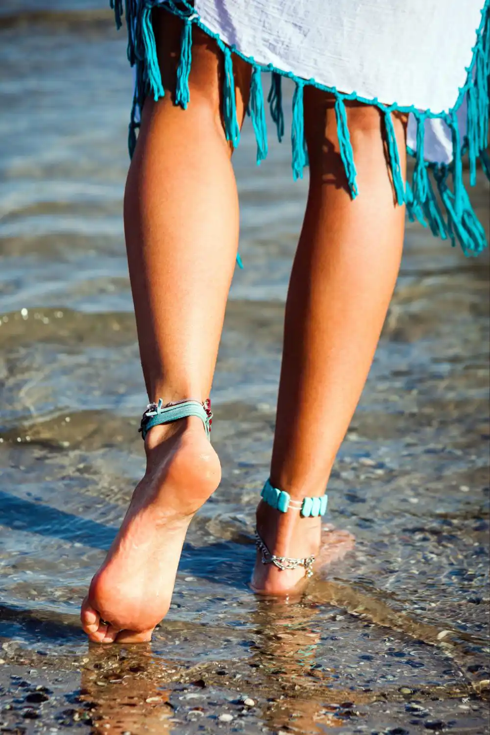 A female walking on the water wearing an anklet
