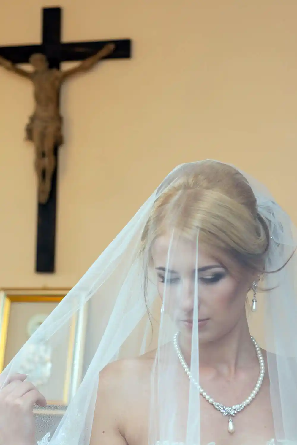 Bride is covered with bridal veiling